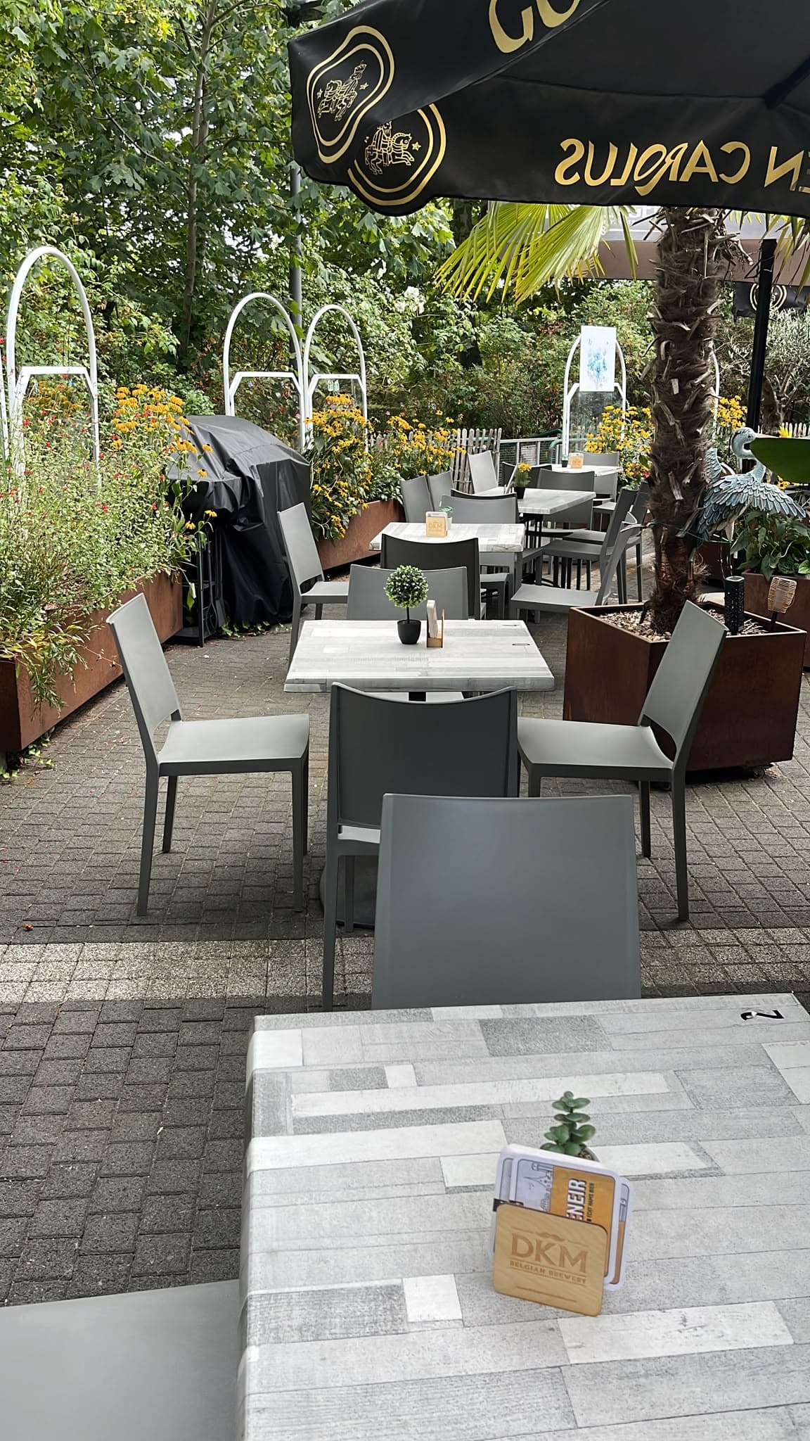 Terras van Het Buurthuis Waasmunster met tafels en parasols