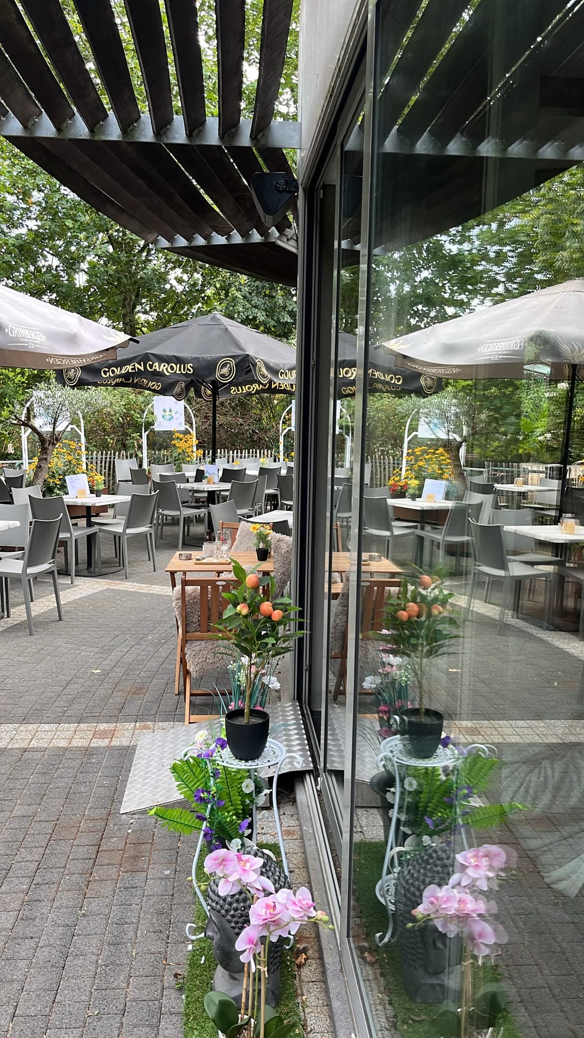 Zicht op het terras van Het Buurthuis Waasmunster vanuit het interieur
